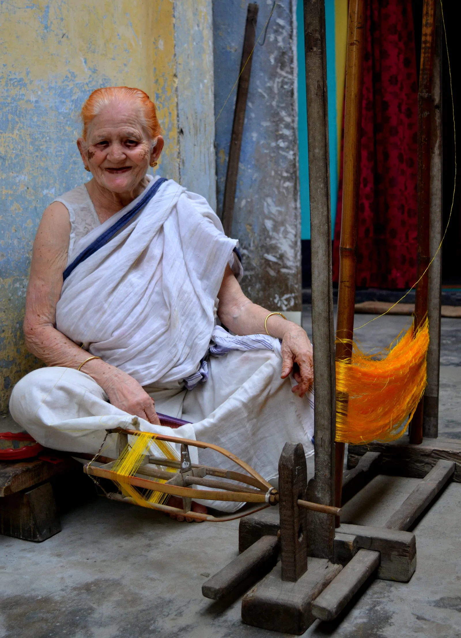 An Assamese woman spinning thread by hand